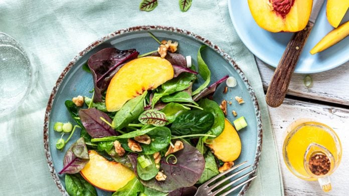 Sommersalat mit Nektarinen auf einem Teller und eine aufgeschnittene Nektarine daneben Mundgefühl Foodblog