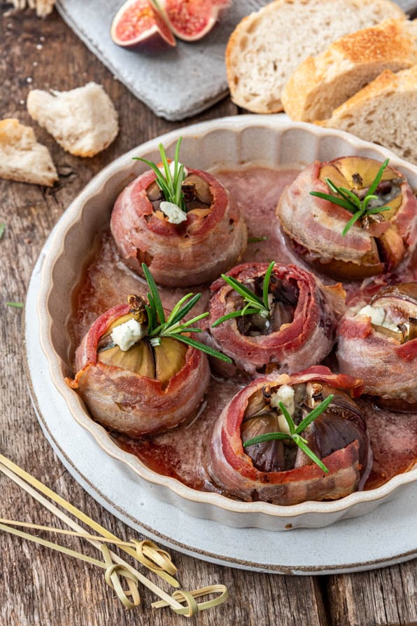 Eine Ofenform mit Feigen im Speckmantel und Baguette - Tapas