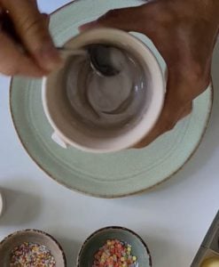 Puderzucker und Zitronensaft werden in Tasse verrührt