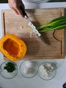 Lauchzwiebeln werden auf Holzbrett geschnitten