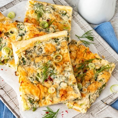 Pizzastücke auf Brett mit Dill