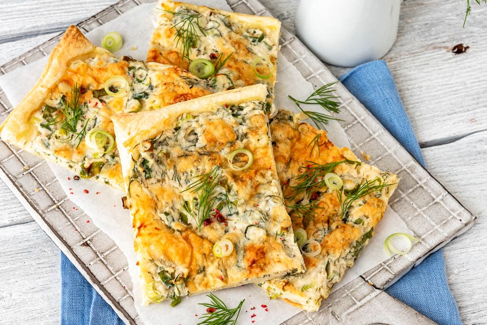 Pizzastücke auf Brett mit Dill