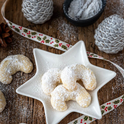 Vanillekipferl Rezept – klassische Kipferl auf Holzbrett mit Puderzucker