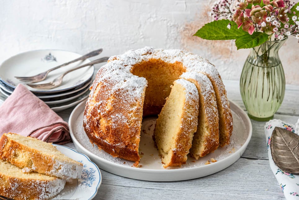 Angeschnittener Kuchen mit Quark und Blumen