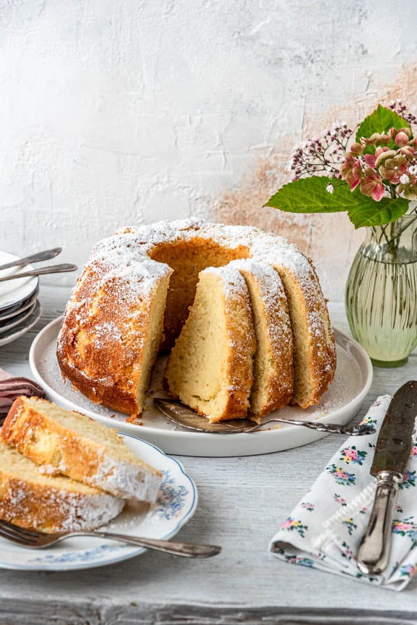 Angeschnittener Quarkkuchen und Blumen