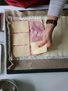 Blätterteig wird mit Schinken und Käse belegt