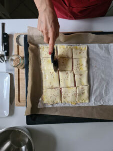 Teig wird mit Pizzaroller geschnitten