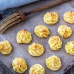 Herzoginkartoffeln auf Backblech mit Pinsel und Küchentuch