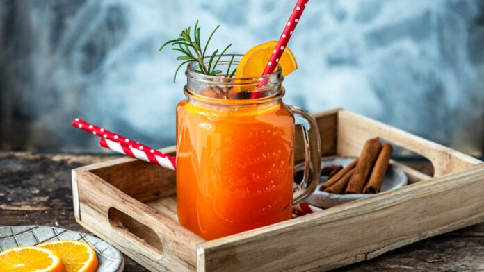 Ein Glas Hot Aperol mit Strohalm auf einem Tablett - Foodblog Mundgefühl
