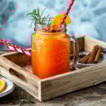 Ein Glas Hot Aperol mit Strohalm auf einem Tablett