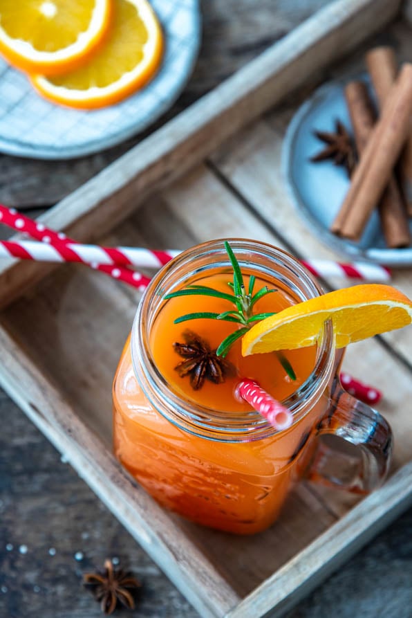 Hot Aperol mit Strohhalm und Zimtstangen auf Tablett