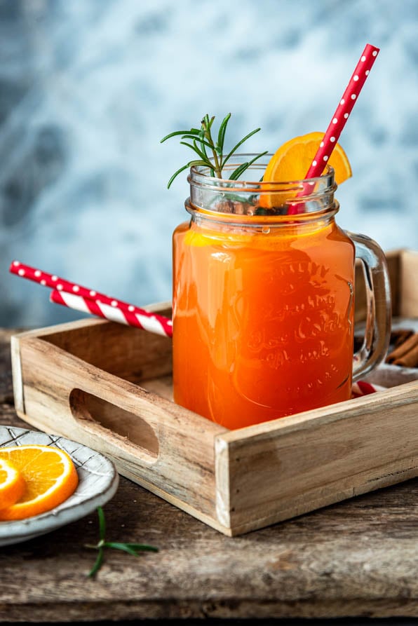 Hot Aperol mit Strohhalm und Zimtstangen auf Tablett