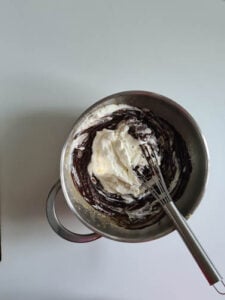 Steife Sahne wird unter Schokomasse gehoben für Mousse au chocolat Rezept