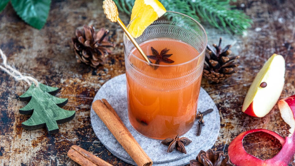 Ein Glas Apfelpunsch mit weihnachtlicher Dekoration