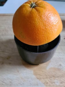 Eine Orange für Apfelpunsch Rezept wird ausgepresst