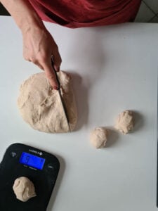 Vom Teig werden Stücke abgeschnitten