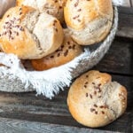 Ein Brötchen liegt vor einem Brotkörbchen