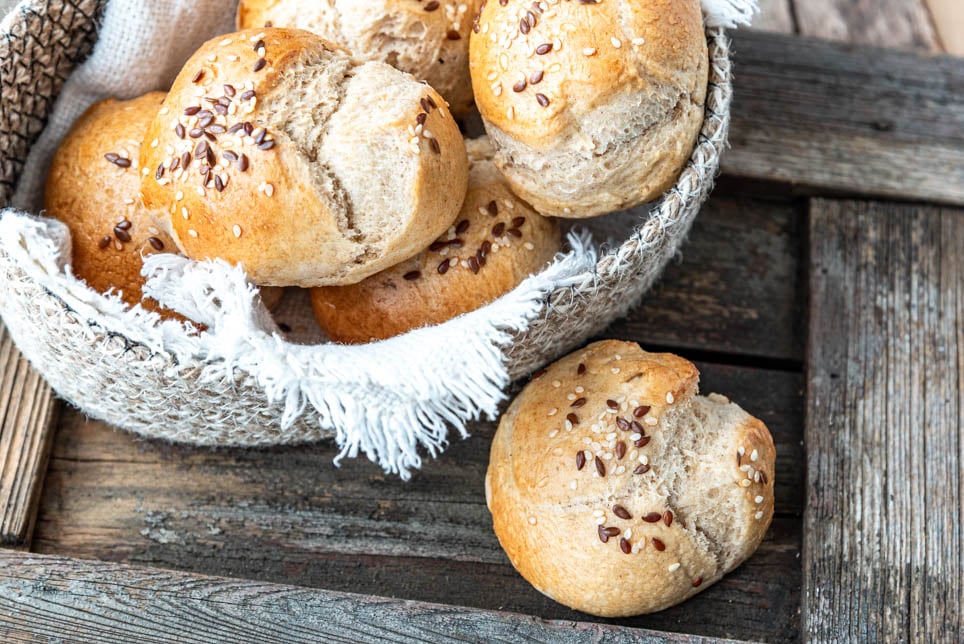 Ein Brötchen liegt vor einem Brotkörbchen
