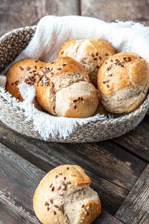 Ein Brötchen liegt vor einem Brotkörbchen