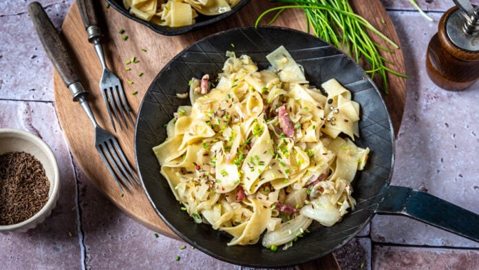 Eine Pfanne mit Krautnudeln auf einem Brett - Foodblog Mundgefühl