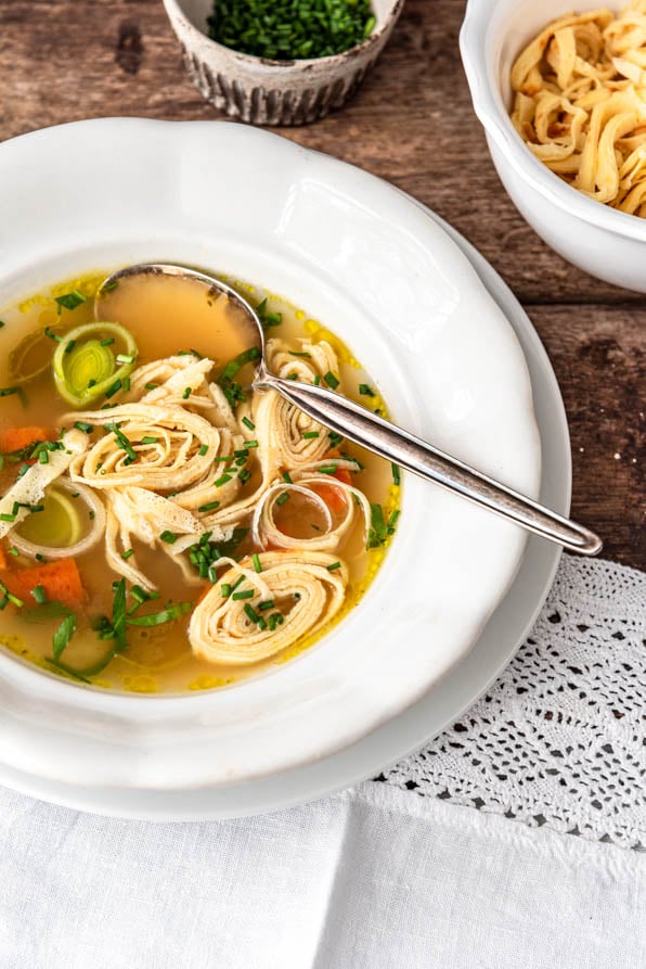 Flädlelsuppe in einem Suppenteller auf Holztisch