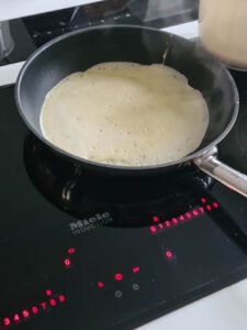 Pfannkuchen für Frittatensuppe werden in Pfanne gebraten