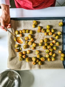 Gewürzter Rosenkohl wird auf Backblech verteilt