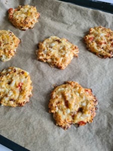 fertig gebackene Taler aus körnigem Frischkäse auf Backblech
