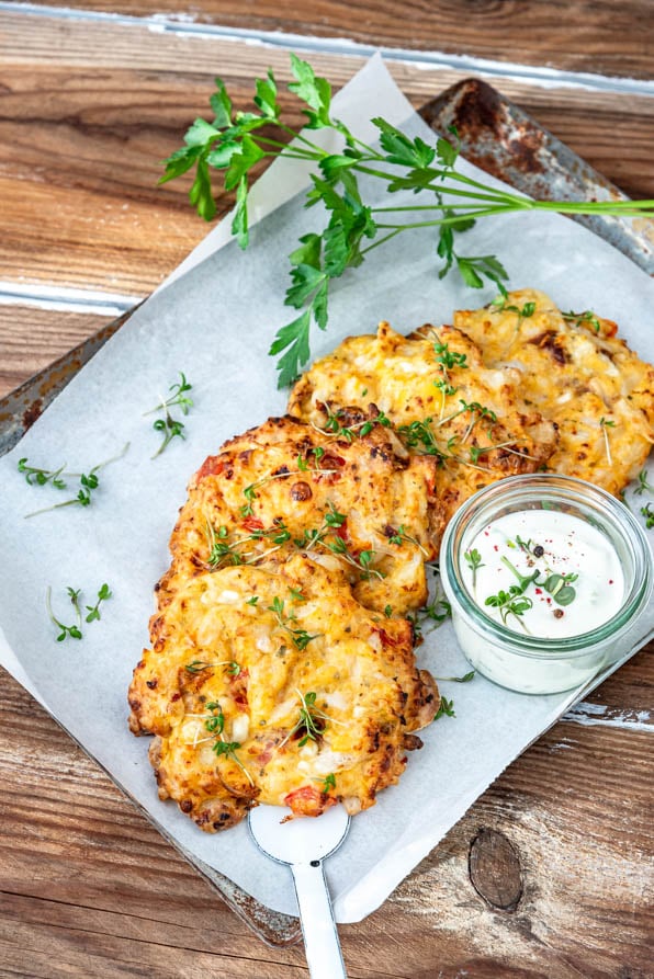 Hüttenkäsetaler aus körnigem Frischkäse mit Dip auf Blech und Petersilie