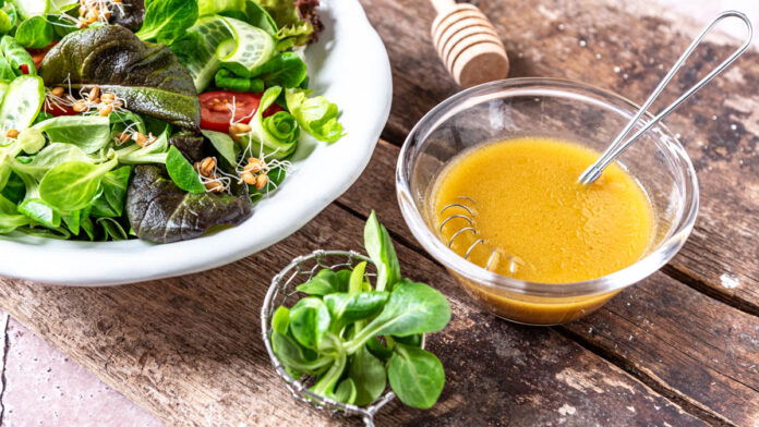 schnelles-honig-senf-dressing Ein Schüsselchen Honig-Senf-Dressing neben Salatteller - Foodblog Mundgefühl