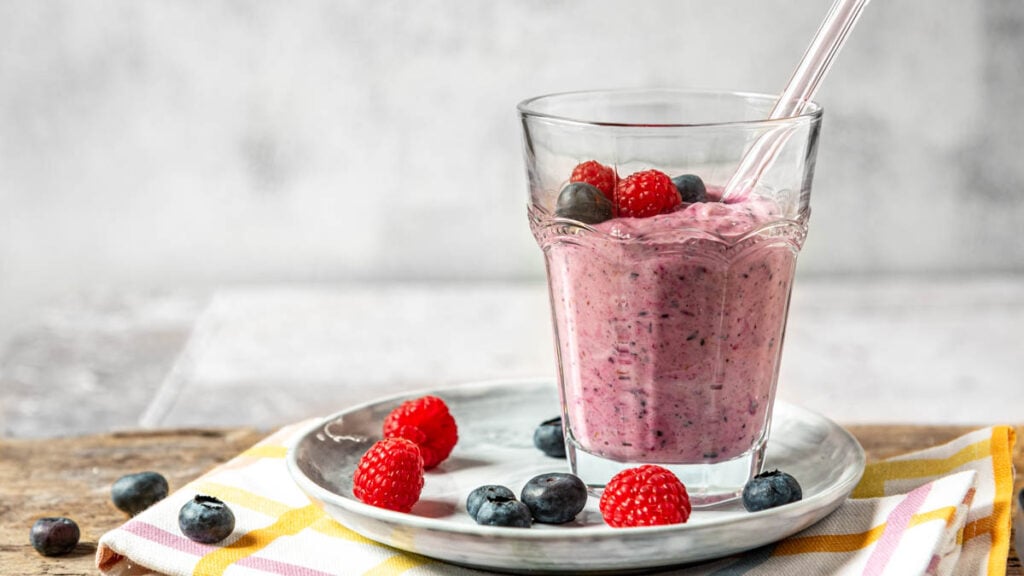 Beeren Smoothie in einem Glas mit Beeren drumherum - Foodblog Mundgefühl