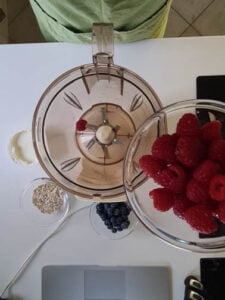 Himbeeren werden in Standmixer gegeben für Beeren Smoothie Rezept