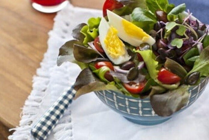 bunter-blattsalat-mit-biss Eine Schüssel Blattsalat mit Eiern, Tomaten und Sprossen