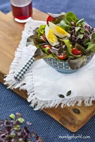 Eine Schüssel mit Blattsalat auf Holzbrett