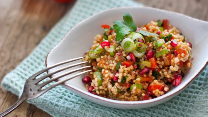 Eine Schale mit Hirserisotto auf Holzuntergrund