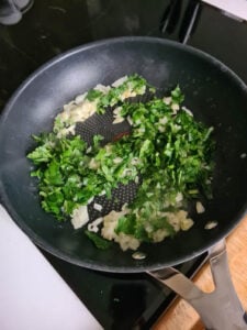 Zwiebel wird mit Petersilie in Pfanne gebraten