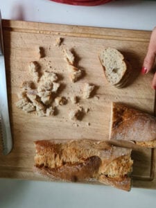 Brot wird in kleine Stücke geschnitten für Kaspressknödel Rezept