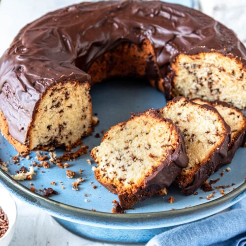 Angeschnittener Ameisenkuchen mit Blumen im Hintergrund