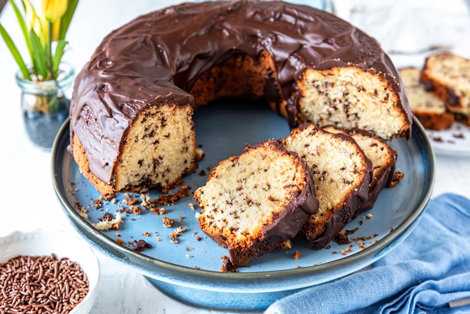 Angeschnittener Ameisenkuchen mit Blumen im Hintergrund