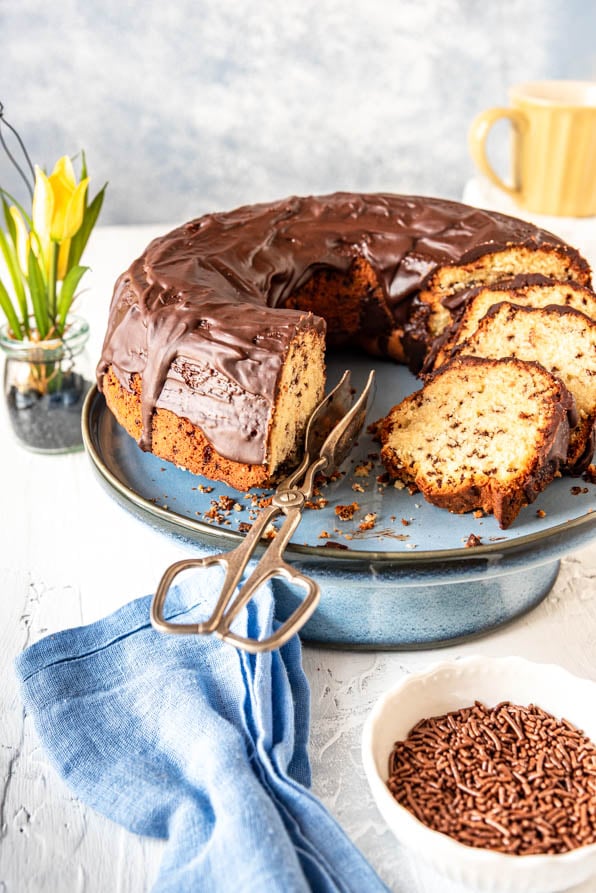 Kuchen mit Schokoguss auf Tortenplatte und Schokostreusel