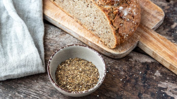 Ein Schälchen Brotgewürz neben einem Laib Brot - Foodblog Mundgefühl