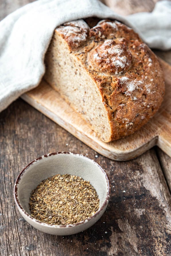 Ein Schälchen Brotgewürz neben einem Laib Brot - Foodblog Mundgefühl