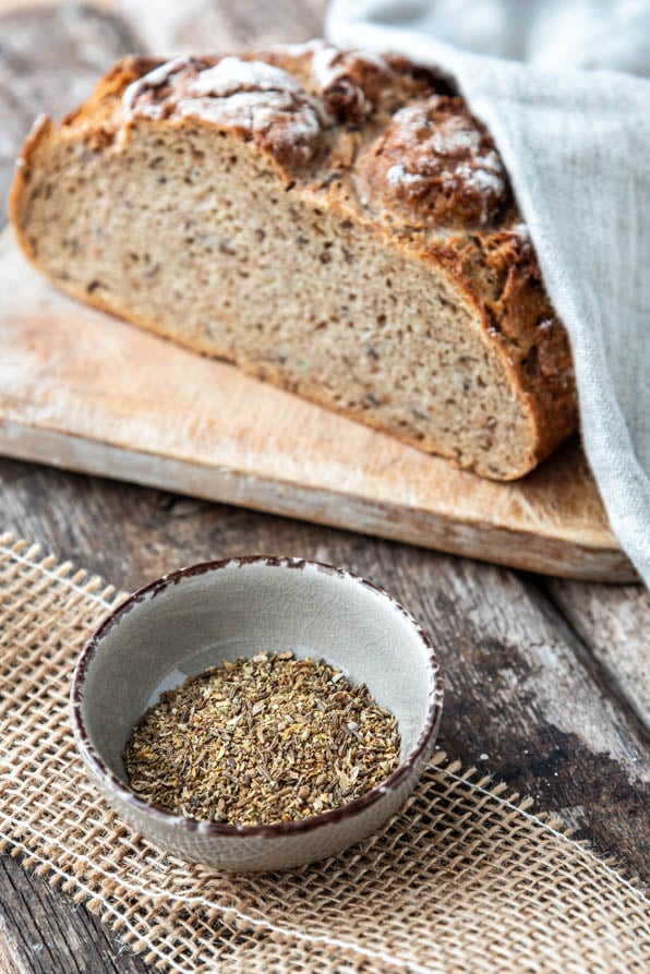 Ein Schälchen Brotgewürz neben einem Laib Brot - Foodblog Mundgefühl