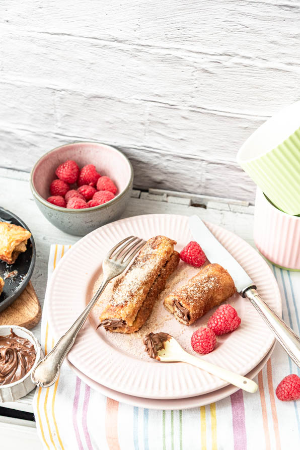 French Toast Rolls mit Nutella und Himbeeren auf Tisch