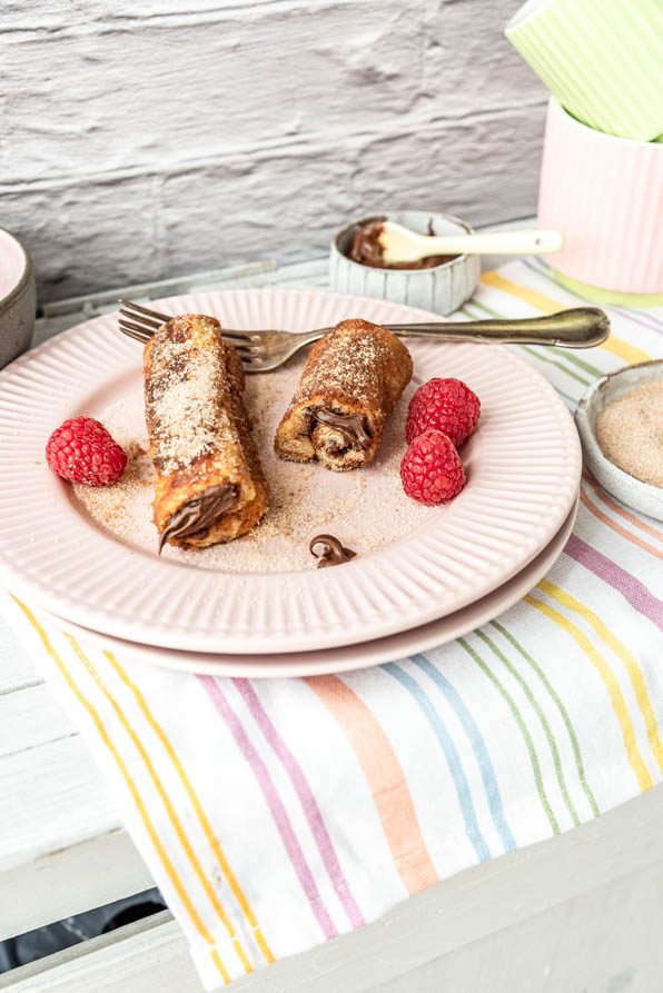 French Toast Rolls mit Nutella und Himbeeren auf Tisch