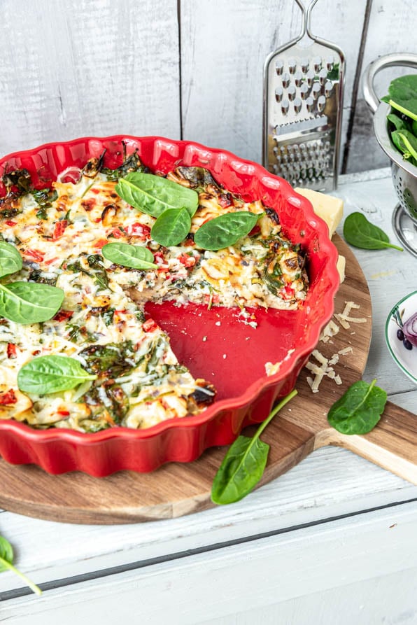 Eine angeschnittene Schüttelpizza in Auflaufform auf Kästchen