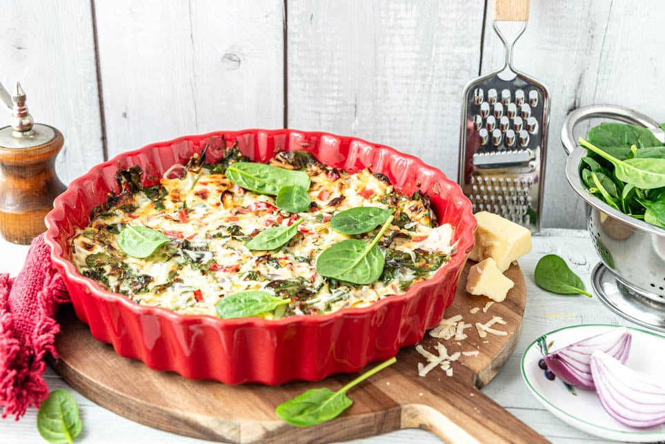 Ein Auflaufform mit Schüttelpizza steht auf Kästchen.