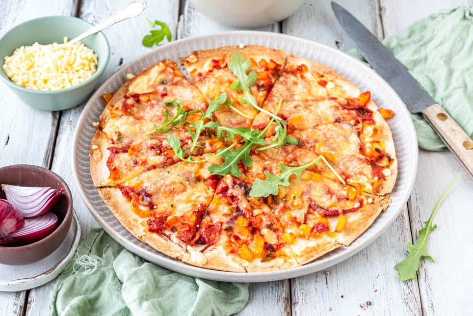 Pizza Wrap mit Käse und roter Zwiebel auf Holzuntergrund