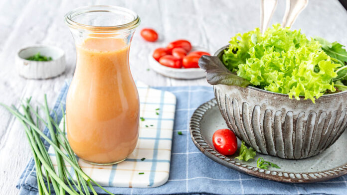 french-dressing-selber-machen Eine Flasche mit Salatdressing neben Salat