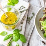 Italian Dressing in Glas mit Salat im Hintergrund
